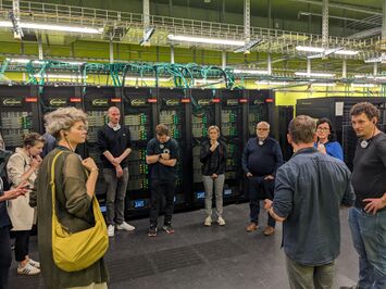 Teilnehmende vor Servern des Hochleistungsrechners der TU Dresden